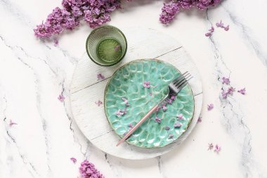 Beyaz grunge arkaplan üzerinde leylak çiçekleri ile güzel masa ayarları