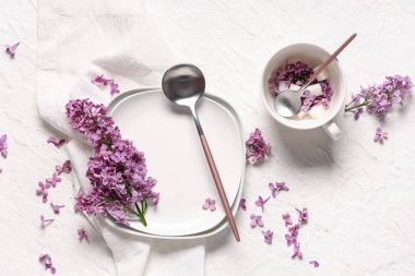 Beyaz grunge arkaplan üzerinde leylak çiçekleri ile güzel masa ayarları