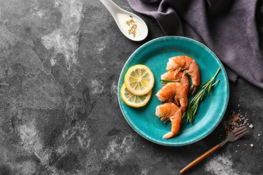 Lezzetli haşlanmış karides, biberiye ve limonlu koyu arkaplan.