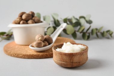 Beyaz arka planda Shea tereyağı olan ahşap kase, yakın plan.