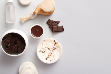 Bir kavanoz çikolatalı tereyağı ve beyaz arka planda erimiş çikolatalı spa kompozisyonu.