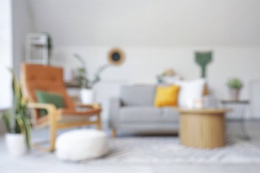 Bulanık oturma odası, gri kanepe, koltuk ve masa.