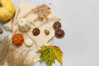 Gri arka planda mumlar, balkabağı ve sonbahar dekoru olan güzel kompozisyon