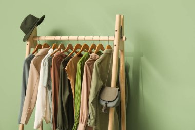 Yeşil duvarın yanında şık elbiselerle dizilin.