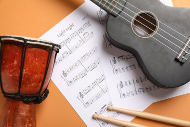 Ukulele, davul, sopalar ve renk arkaplan notaları, yakın plan