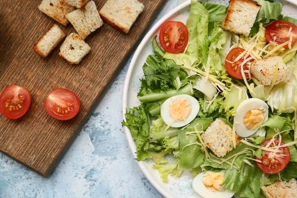 Mavi arka planda lezzetli Sezar salatası tabağı, yakın plan.