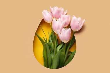 Sarı arka planda güzel lale çiçekleri olan paskalya yumurtası şeklinde kesilmiş kahverengi kağıt.