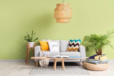 Oturma odasının içinde sörf tahtası, kanepe ve lamba var.