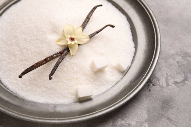 Arkaplanda tatlı vanilya şekeri tabağı, yakın plan.