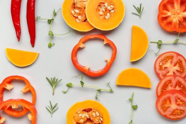 Gri arka planda taze sebzeler ve bitkilerle yakın plan kompozisyonu.