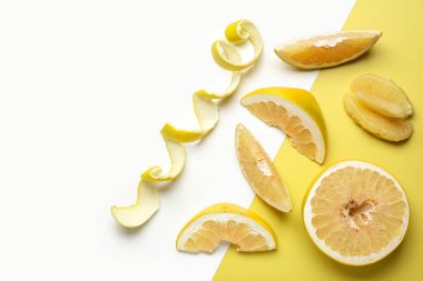 Dilimlerle tatlı pomelo kes ve renkli arkaplanda kabuk soy