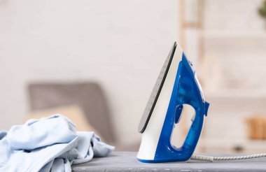 Mavi ütü ve giysiler odada.