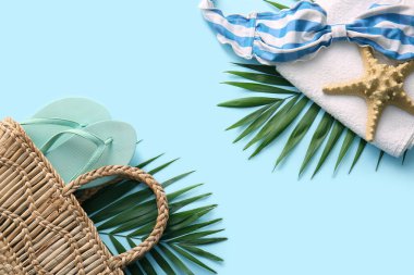 Renkli arka planda şık plaj aksesuarları ve palmiye yaprakları olan kompozisyon