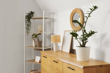 Oturma odasındaki ışık duvarında asılı şık bir ayna.