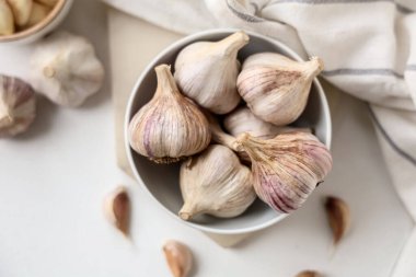 Beyaz arka planda taze sarımsaklı kase