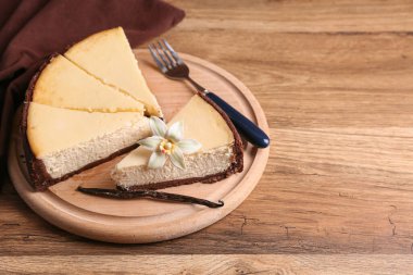 Tahta zemin üzerinde tatlı vanilyalı cheesecake parçaları olan tahta.