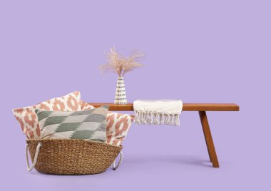 Dekoratif yastıklı sepet ve leylak arka planda bank