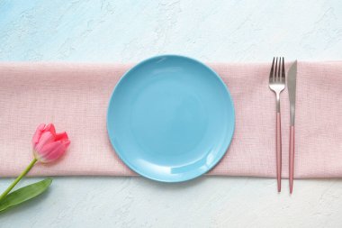 Açık mavi arkaplanda pembe lale çiçekli güzel bir masa.