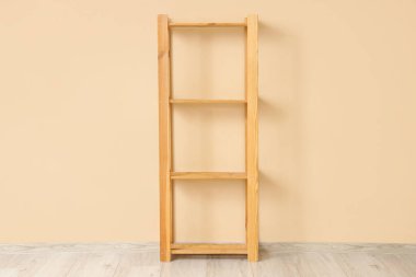 Bej duvarın yanında boş ahşap raf ünitesi