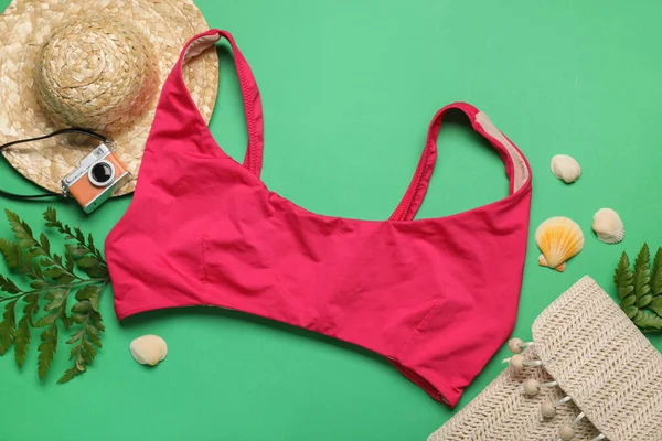 Yeşil arka planda mayo, çanta ve şapka ile yaz kompozisyonu, yakın plan