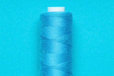 Mavi arkaplanda iplik makarası, yakın plan