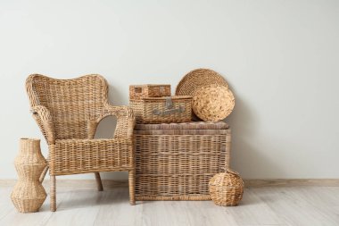 Şık oturma odasının içinde rattan koltuk ve farklı hasır sepetler var.