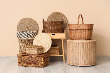 Farklı hasır sepetler ve şık bir odada bej duvarın yanındaki masa.