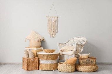 İçinde rattan koltuk, sehpa ve farklı hasır sepetler olan şık bir oturma odası.