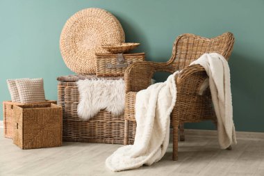 Şık oturma odasının içinde rattan koltuk ve farklı hasır sepetler var.