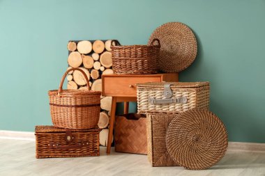 Farklı hasır sepetler ve şık bir odada mavi duvarın yanındaki masa.