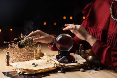 Kristal küreli falcı ve masada geleceği okuyan beyaz bilge.