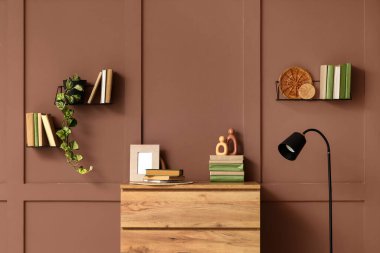 Ahşap şifonyer, kitaplar ve standart lamba ile şık ev kütüphanesinin bulanık görüntüsü