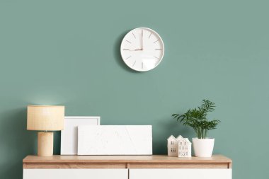 Odadaki naneli duvarda dekor ve saat olan çekmeceler.