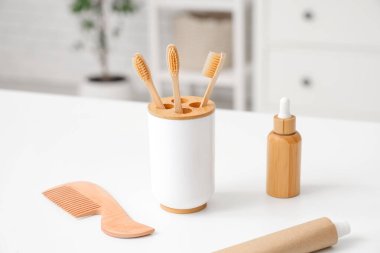 Tuvalet eşyası ve bardakla diş fırçası banyoda, yakın plan.