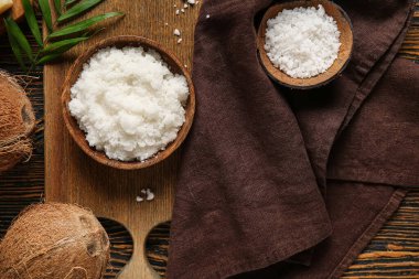 Composition with natural body scrub, sea salt, coconuts and napkin on wooden background