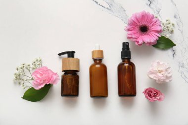 Farklı kozmetik ürünleri ve açık arkaplanda güzel çiçekler