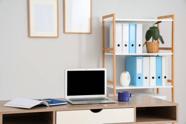 Modern dizüstü bilgisayarı ve kahve fincanı olan işyeri ofis içi, yakın plan.