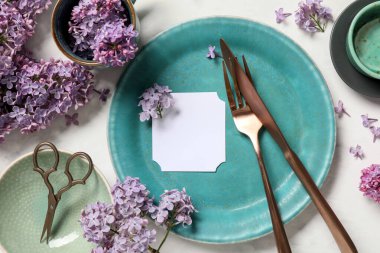 Boş kart ve beyaz arka planda leylak çiçekleri ile güzel masa ayarları