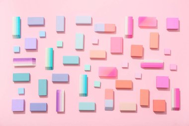 Pembe arka planda farklı silgi içeren kompozisyon