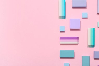 Pembe arka planda farklı silgi içeren kompozisyon