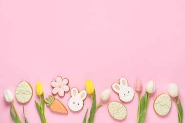 Paskalya kurabiyeleri ve pembe arka planda lale çiçekleri.