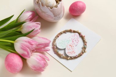 Tebrik kartı ve beyaz arkaplanda laleler olan kompozisyon. Paskalya kutlaması