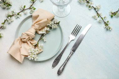 Açık mavi arkaplanda çiçek açan dalları olan güzel masa ayarları