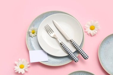 Pembe arka planda güzel kasımpatı çiçekleri olan şık bir masa.