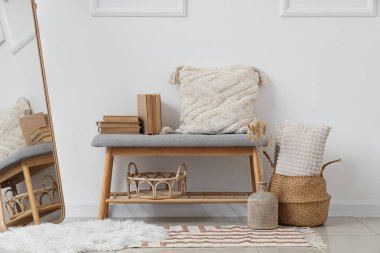 Işık odasında kitap ve yastıklı yumuşak bir bank.