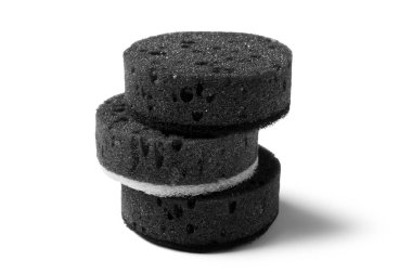 Beyaz arkaplanda yuvarlak siyah temizlik süngeri yığını