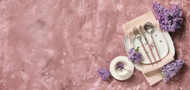 Gümüş çatal bıçak takımı ve pembe grunge arkaplan üzerinde leylak çiçekleri ile güzel masa ayarları metin için boşluk ile
