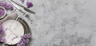 Beautiful table setting with lilac flowers on grey grunge background with space for text
