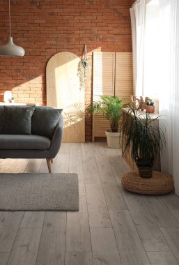 Gri kanepesi ve penceresi olan bir çatı katı tarzı oturma odası.