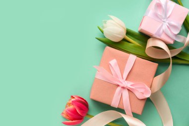 Turkuaz zemin üzerinde laleler olan hediye kutuları. Mutlu Kadınlar Günü